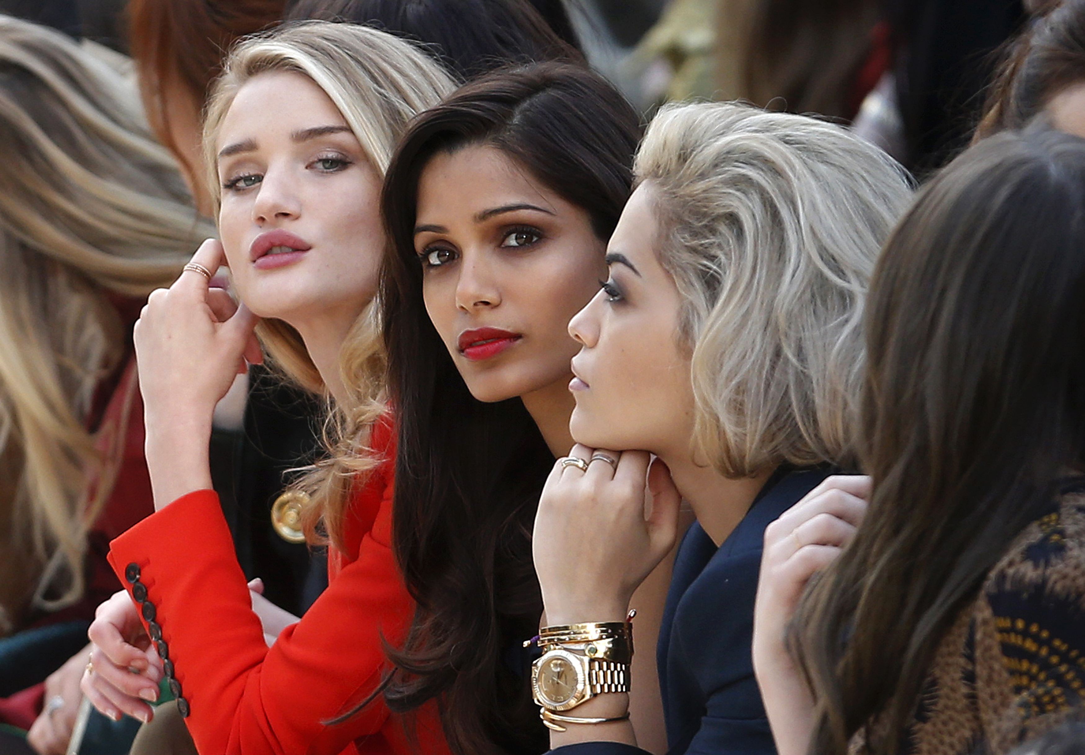 Model and actress Rosie Huntington-Whiteley, actress Freida Pinto and singer Rita Ora watch the presentation of the Burberry Prorsum Autumn/Winter 2013 collection during London Fashion Week